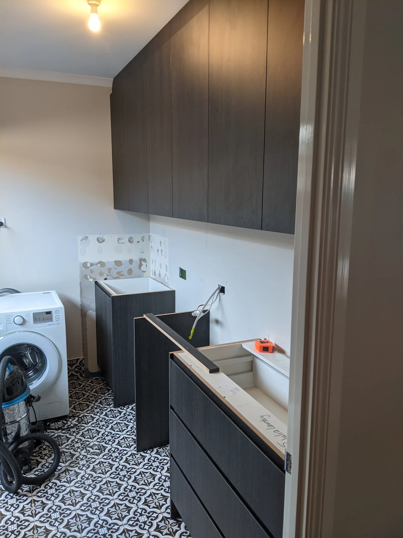 Laundry during installation, showing the new dark cabinetry before the work surface was fitted